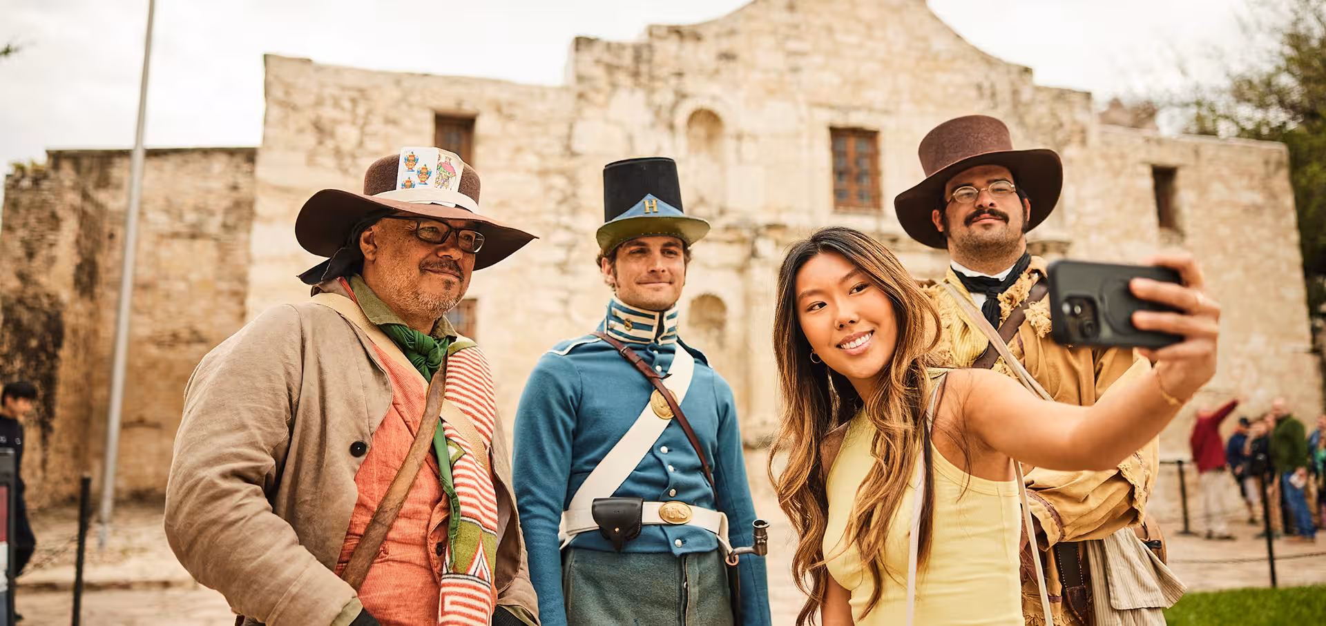 Girl taking a selfie with Alamo staff in costume